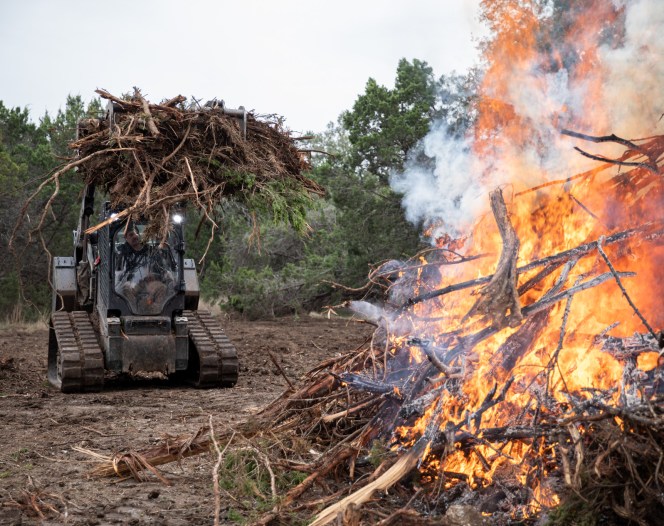 skid steer adding brush to fire