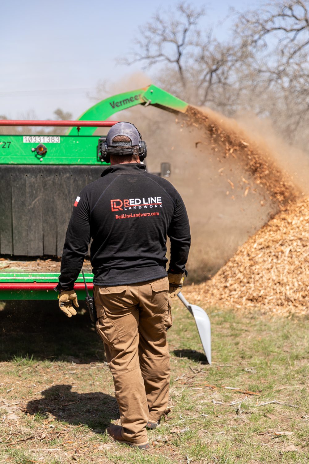 Worker standing in front of wood chipper